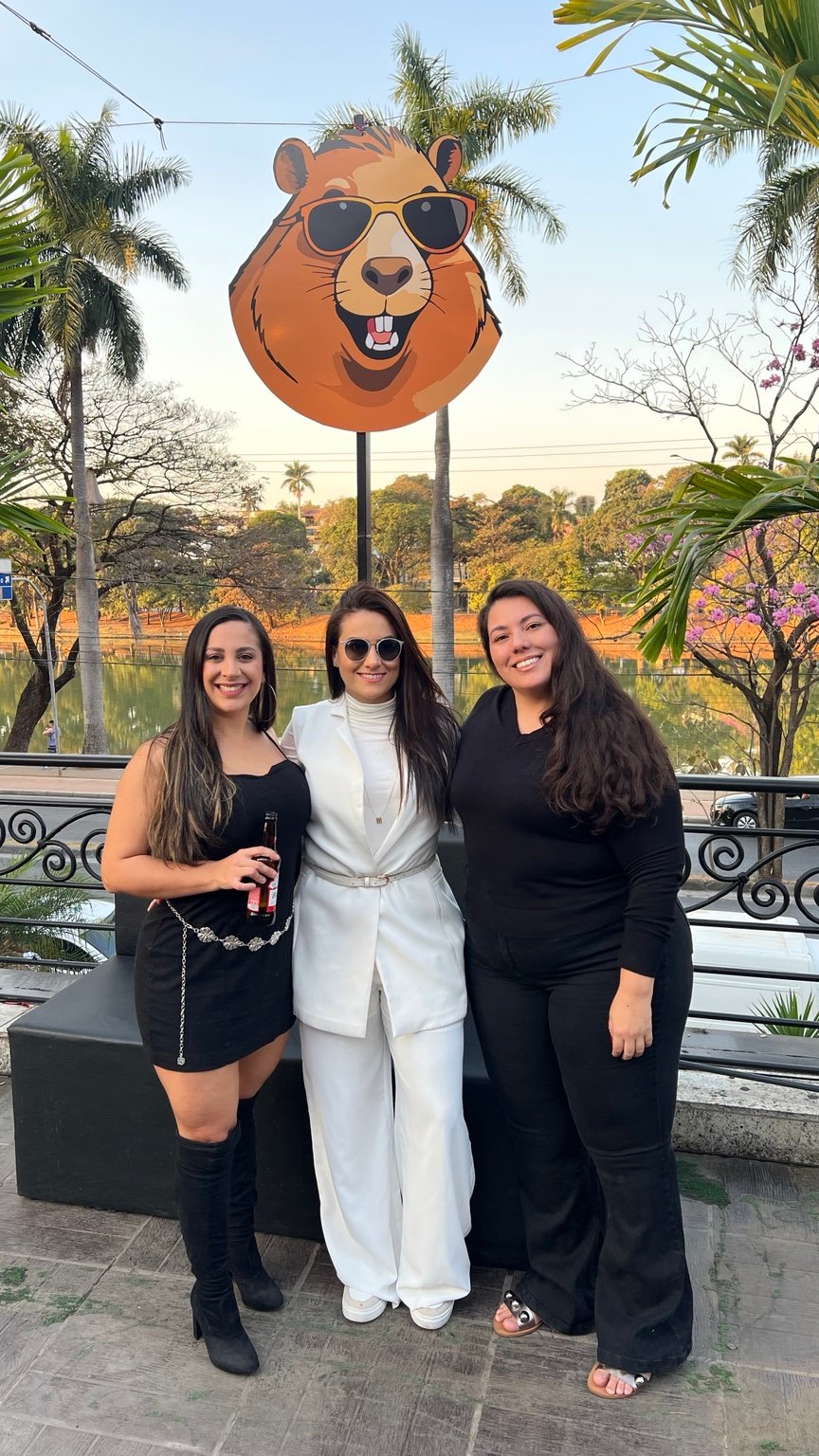 Fê em um evento, ao lado de duas amigas